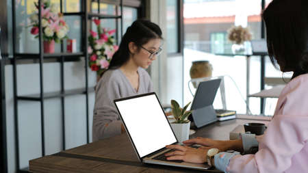 Two businesswoman are working on computer tablet in a modern business lounge.の写真素材