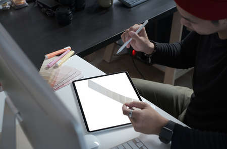 An Asian attractive businessman relaxing at his workspace and putting legs on table in office.