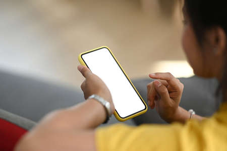 Close up view of woman holding mobile phone with white blank screen that can put any idea and...