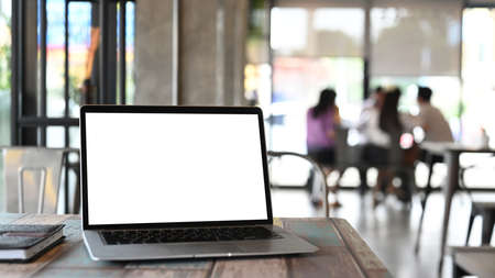 An open laptop with blank screen on wooden table and blur modern meeting room background.の写真素材
