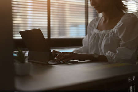 Portrait a smiling businesswoman is working at her desk with computer tablet in modern office .