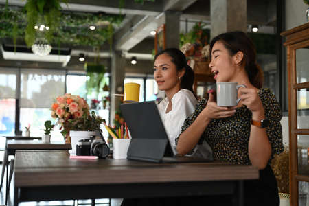 Shot of two businesswomen are using computer tablet and discussing new project at modern office.の写真素材