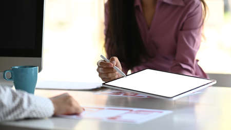 Top view of freelancer workspace with blank screen laptop, mobile phone, coffee cup and notebook on...