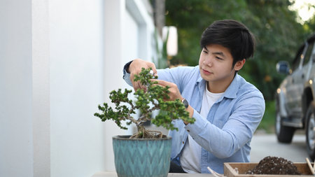 A man gardener is watering plant at home.の写真素材