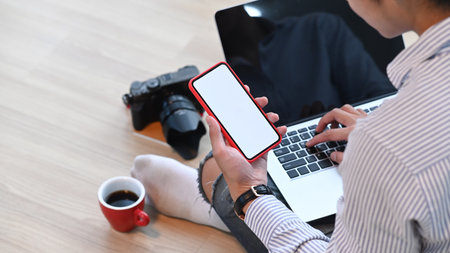 Image of man hands are holding and touch on empty screen mobile phone at office.