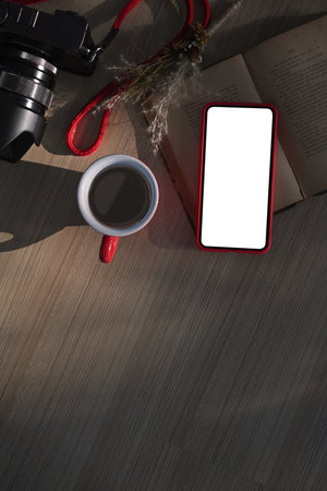 A digital tablet with white screen and coffee cup on wooden table. White empty space for advertise...