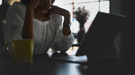 Cropped shot of young Asian businesswoman using mobile at white office desk.
