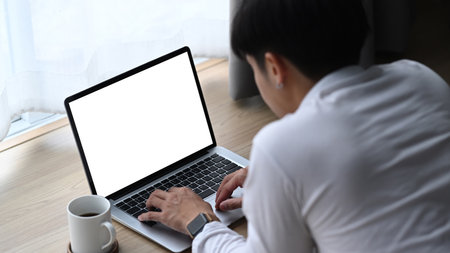 Graphic designer in red wool hat working on digital tablet and looking at camera while sitting at...