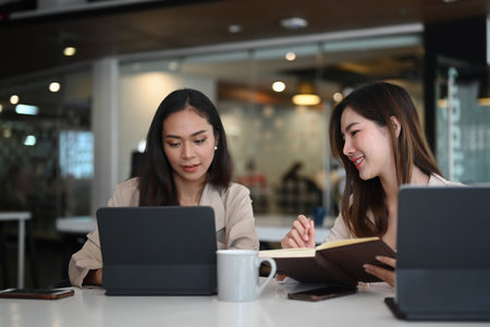 Two businesswoman partners discussing  together on business project and using computer tablet.の写真素材