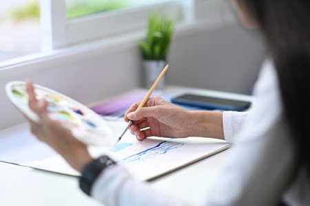 A young Graphic Designer Working on a digital tablet  and sitting at her workstation.の写真素材