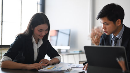 Two business people analysts and discussing online data while sitting in modern co working.の写真素材