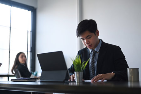 Businesswoman having business conversation with herÂ coworker discussing new project in office.の写真素材