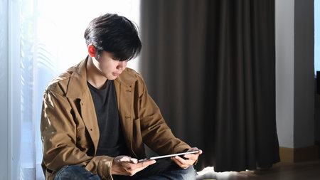 Rear view of businessman working with computer while sitting in modern office.