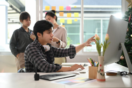 Active teamwork of young asian designer working and brainstorming together in modern office.の写真素材