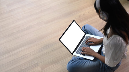 High angle view of creative freelancer sitting on the floor in and working on laptop computer.