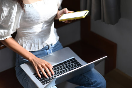 Close up view of businesswoman hand holding stylus pen writing on screen of digital tablet while sitting in modern office.の写真素材
