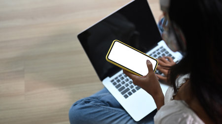 Overhead shot of female freelancer holding stylus pen writing on screen of tablet while sitting with...