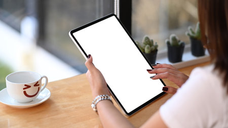 Cropped shot of young female owner taking order from customer with tablet computer in coffee shop.