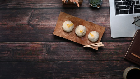 Top view of young designer hands holding digital tablet surrounded by stationery and coffee cup on gray table.の写真素材