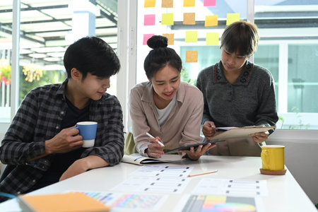 Group of young Asian creative designer brainstorming and discussing on new project at office.の写真素材