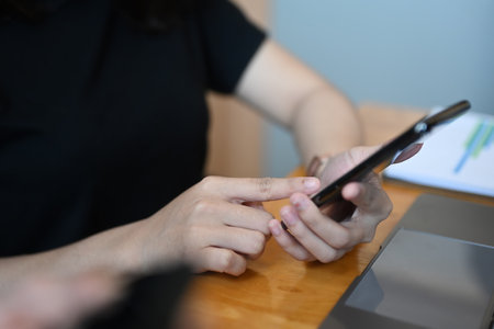 Two casually dressed young business colleagues working with laptop computer while sitting together in modern office.の写真素材