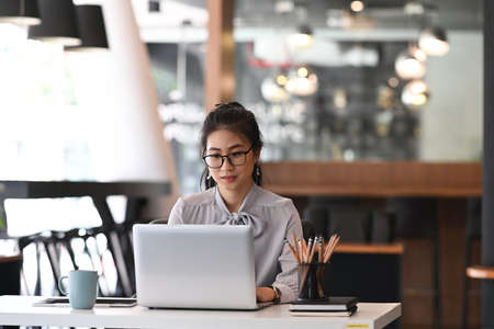 Happy businesswoman receiving good news in email on laptop computer at office.