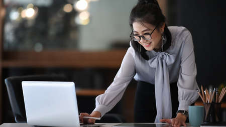 Happy businesswoman receiving good news in email on laptop computer at office.の写真素材