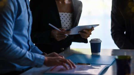 Close up view of young female employee working on laptop commuter at office desk.の写真素材