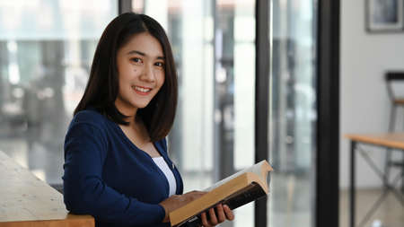 Happy businesswoman  relaxing in comfortable office and stretching during break after work done.の写真素材