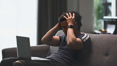 Portrait of businessman sitting at his workplace and reading information on screen of computer.の写真素材