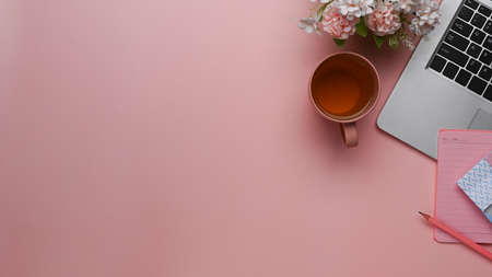 Flat lay women office desk with notebook coffee cup,pink bouquet and stationery on pastel pink background.の写真素材