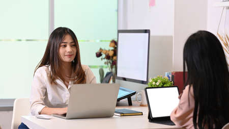 Two young designer working and sitting together in creative office.の写真素材