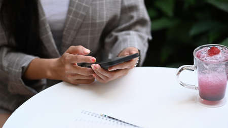 Close up view businesswoman typing on keyboard of tablet computer and writing note at office desk.の写真素材