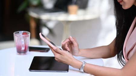 Young female freelance working with laptop computer and writing her idea on notebook.