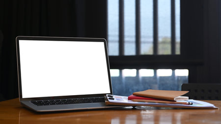 Modern office desk with laptop computer, notebook and documents.の写真素材