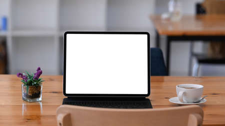 Overhead shot of contemporary workspace with laptop computer, coffee cup, notebook and copy space on...