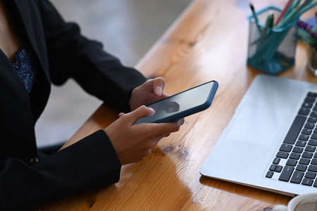 Horizontal image of dark office desk with digital tablet, stylus pen, laptop, coffee cup and...