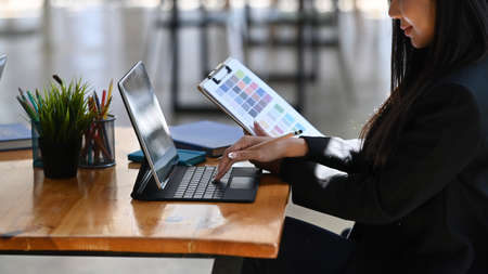 Portrait of confident businesswoman in suit standing with crossed near office window.