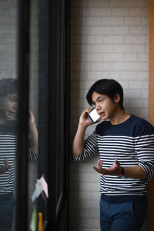 Side view of young man working on modern computer at home.の写真素材
