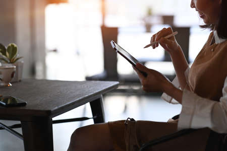 Young female freelance concentrate working on digital tablet at her workplace.の写真素材