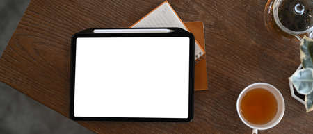 Side view of computer laptop with empty screen and digital tablet on wooden tale at office.