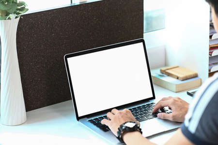 Cropped shot of young man drinking coffee during working online with computer laptop at home.