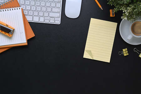 Overhead shot of young female designer holding digital tablet and stylus pen on orange background.の写真素材