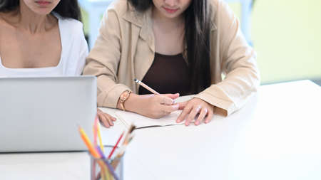 Young asian woman waitress holding digital tablet receiving orders from customers.の写真素材