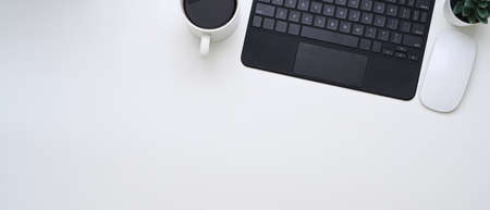 Accountant workplace with computer tablet, books calculator and coffee cup on dark modern office desk.の写真素材
