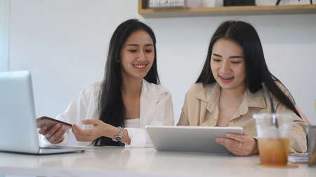 Two young woman small business entrepreneur planning a marketing plan to improve the quality of their sales.の写真素材
