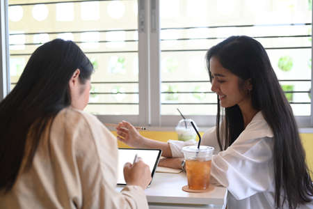 Two young woman small business entrepreneur planning a marketing plan to improve the quality of their sales.の写真素材