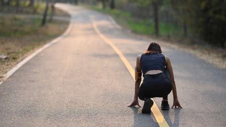 Young asian woman preparing for start morning jogging session in the park.の写真素材