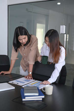 Two businesswoman working with business documents and discussing new project in office.の写真素材