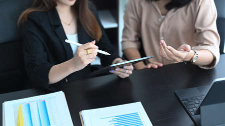 Cropped shot of businesswoman using digital tablet and explaining details of investment to her partnership.の写真素材